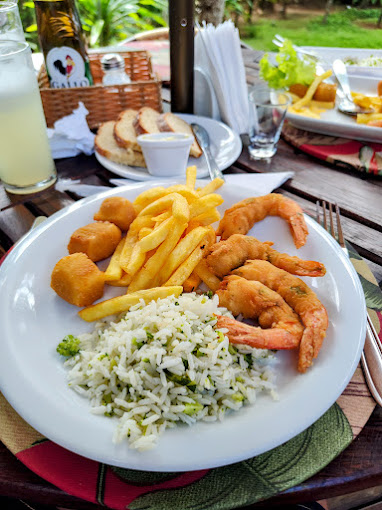 Prato com camarões, fritas e arroz de brócolis na varanda